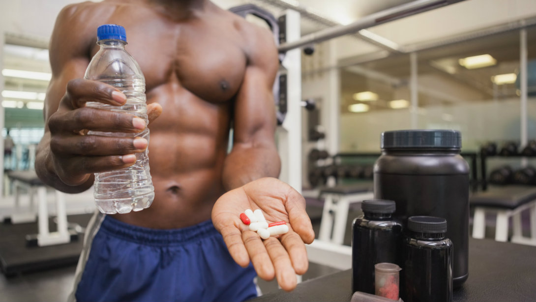 man taking supplements at gym