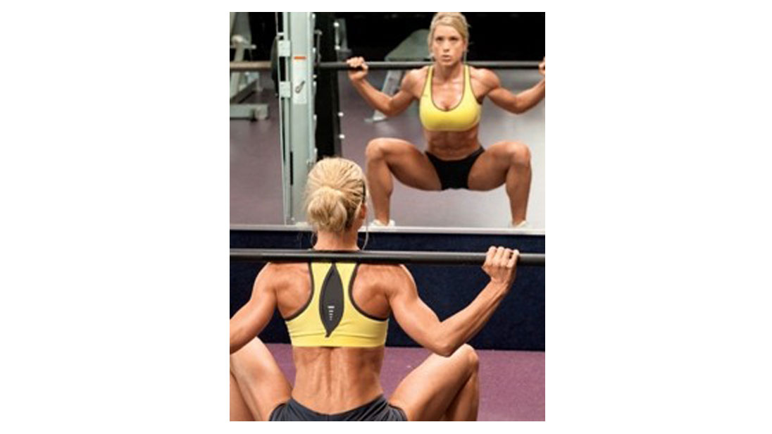 woman doing squatting exercise with barbell