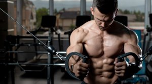 Muscular fitness model working out for a six pack abs doing cable pull out exercise