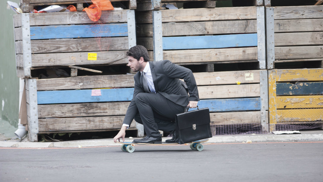 man skateboarding to work in suit