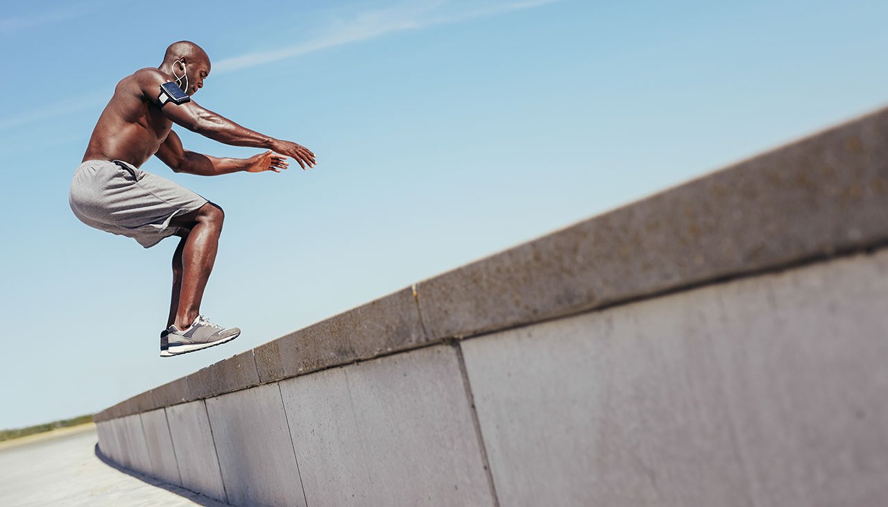 Man Jumping On Ledge For Exercise