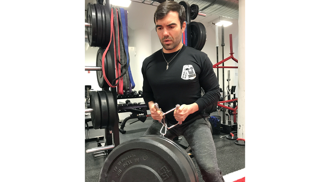 Man lifting weights in Rags of Honor t-shirt. 