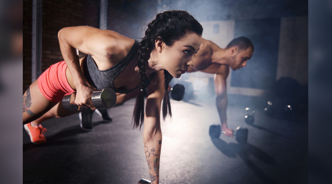 Man And Woman Doing Plank Rows With Dumbbells