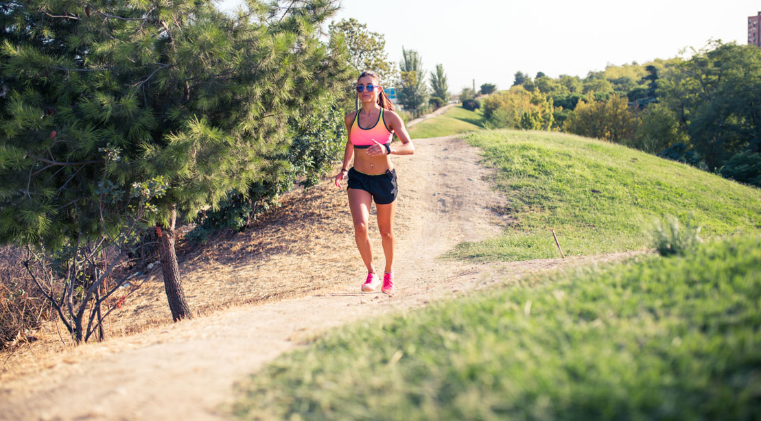 Woman Trail Running Outdoors In Tank and Shorts 