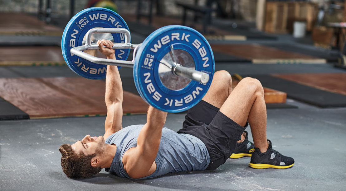 Man working out with partial range of motion exercises Trap bar floor press