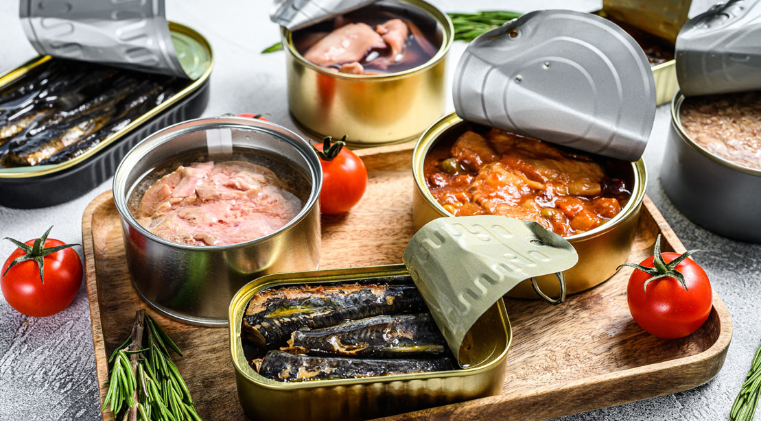 A Variety Of Canned Fish Displayed On A Cutting Board