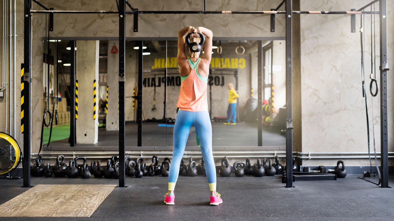 Woman in Gym Lifting Kettlebell