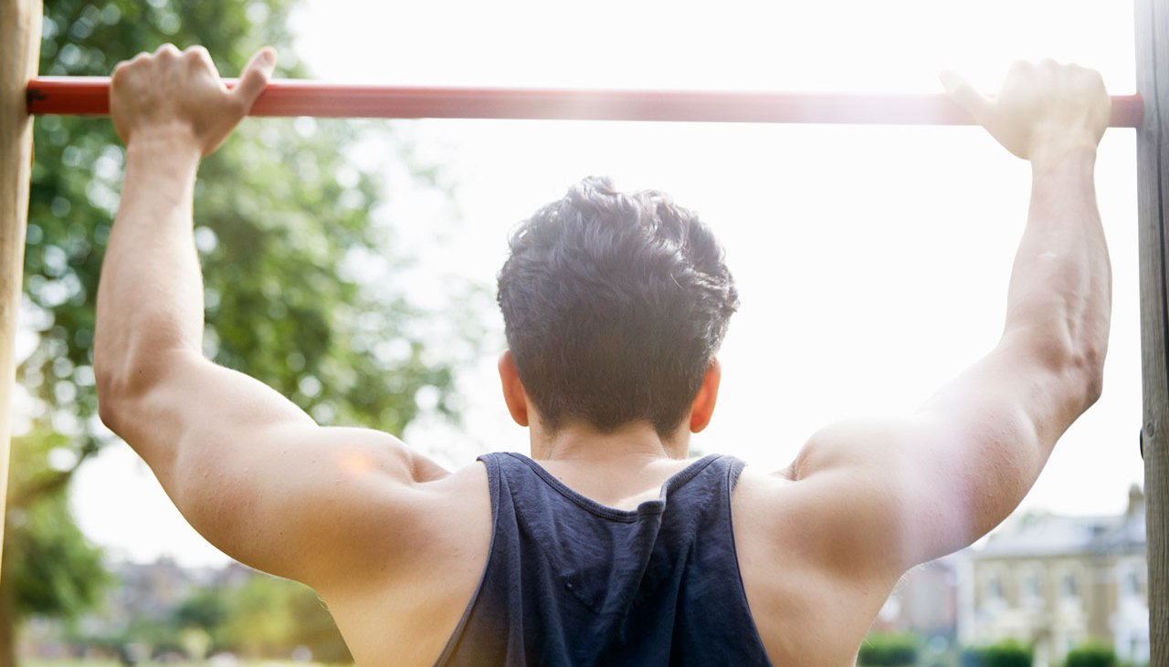 Man doing pullups outdoors in park