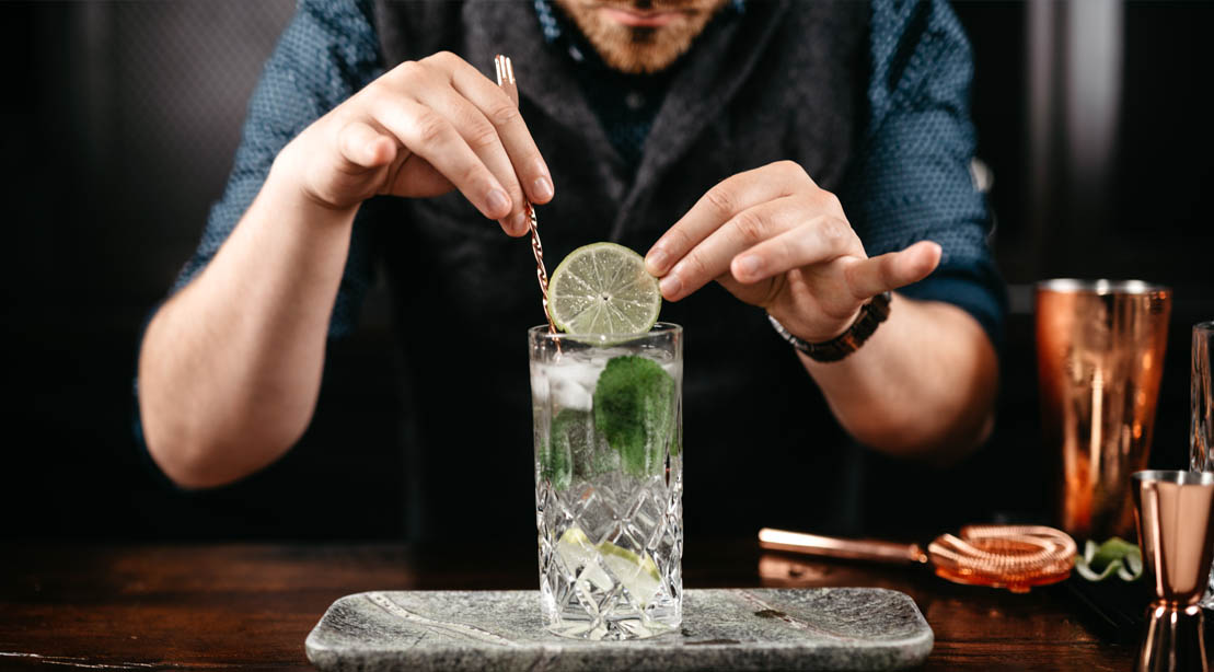 Bartender and mixologist preparing a lime vodka cocktail drink
