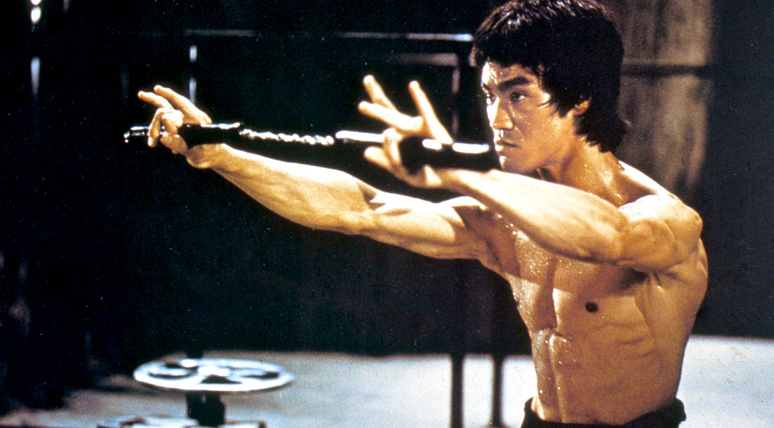 Martial artist and kung fu legend Bruce Lee holding up Nunchucks
