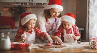 Happy mother teaching her son and daughter to bake healthy holiday treats