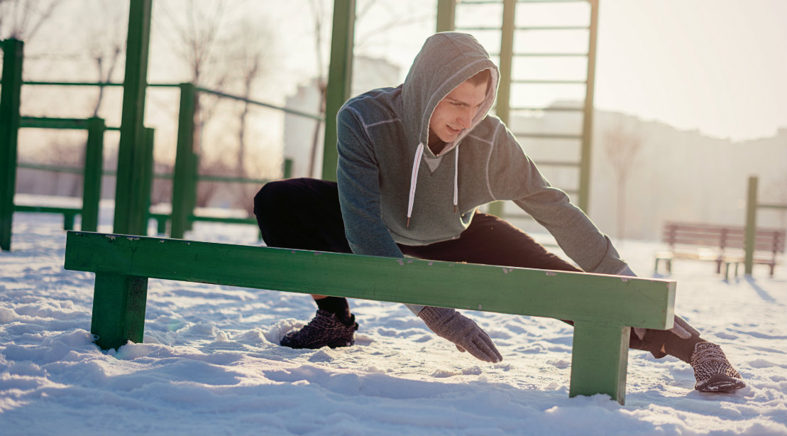 The man is stretched out in the snow.
