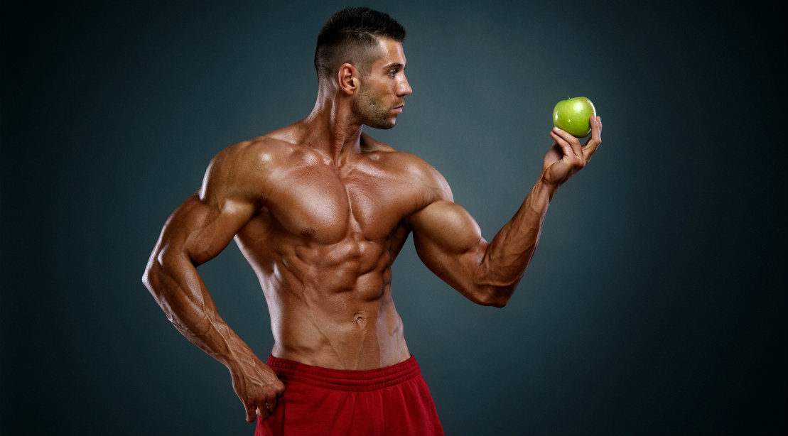 Bodybuilder holding apple