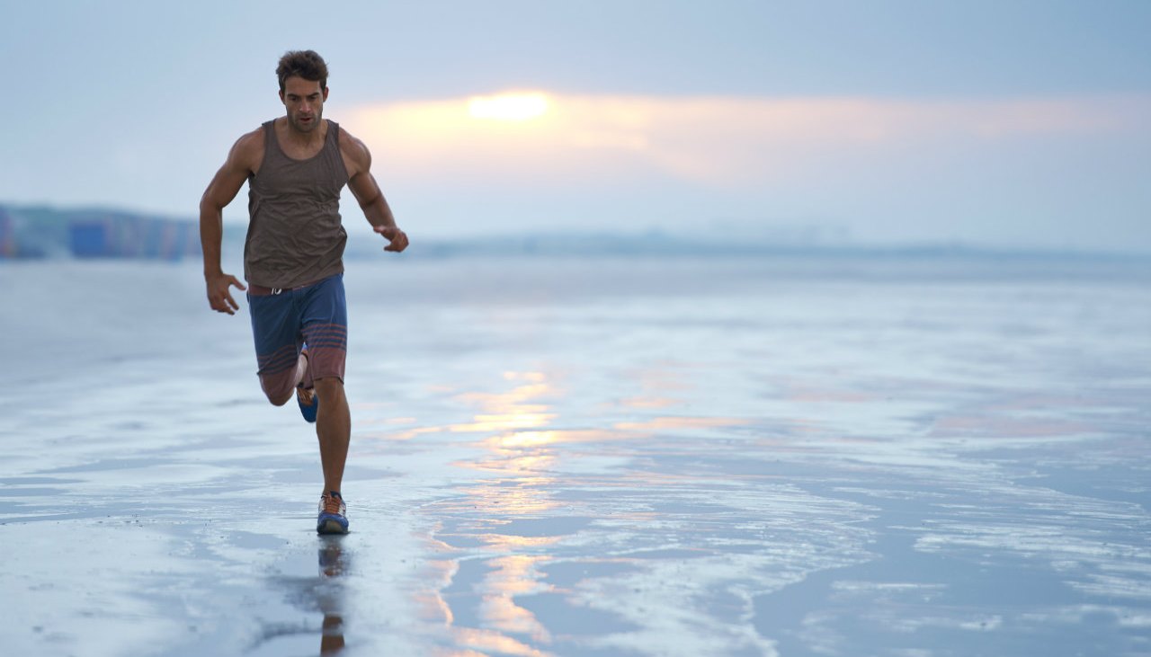 Man running along shore at beach