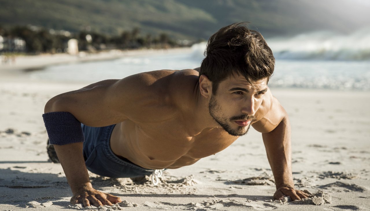Man doing pushups on the beach