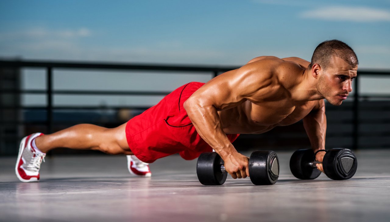 Man doing pushups with dumbbells