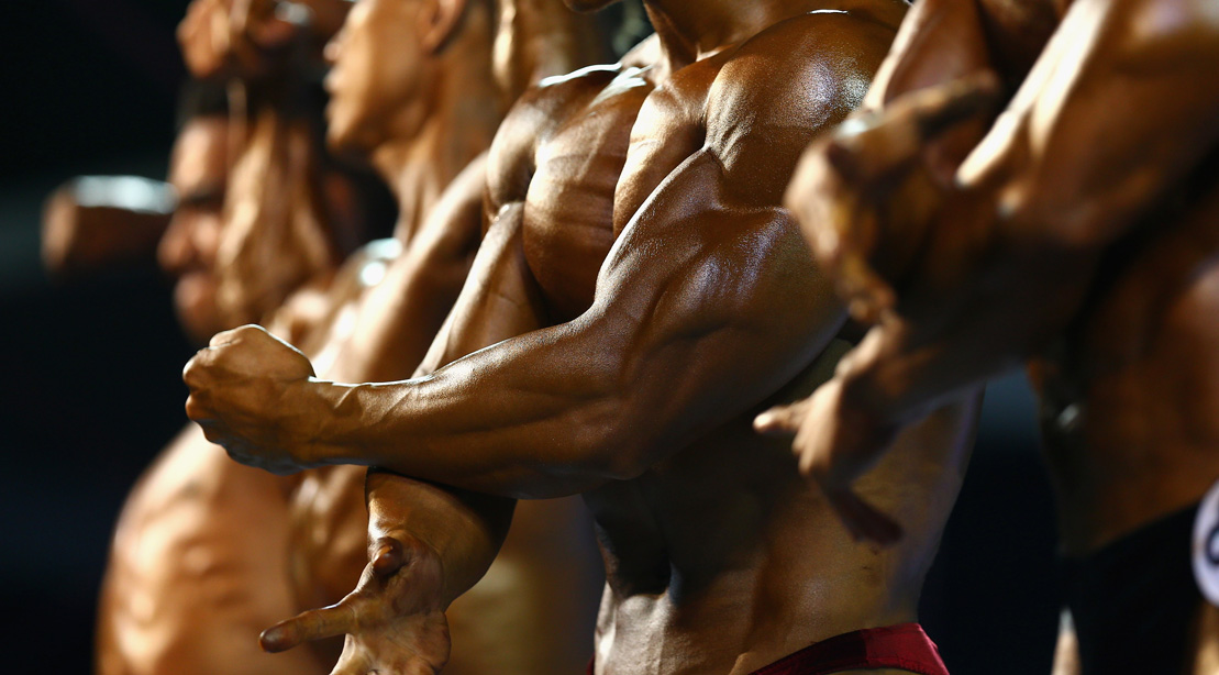 Bodybuilders on stage displaying muscle mass linked to Dianabol use