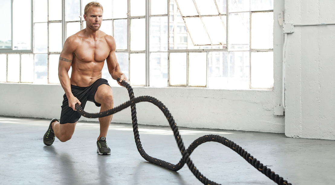 Fit man performing battle rope exercises for The Battle-Rope Finisher for Muscular Endurance