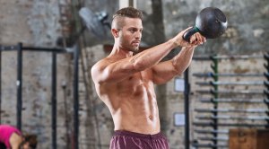 Lean muscular fitness model working out with a kettlebell swing exercise and fixing his kettlebell swing mistakes