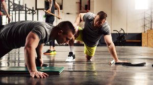 Personal Trainer motivating his client to do more pushups