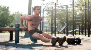Fit male doing the best tricep workout with a bench dip exercise
