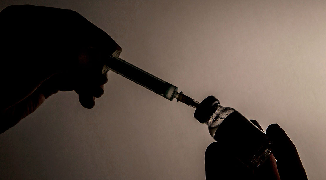 Testosterone vial and syringe representing anabolic steroid use