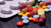 Tabletes multicoloridos, comprimidos na mesa de madeira