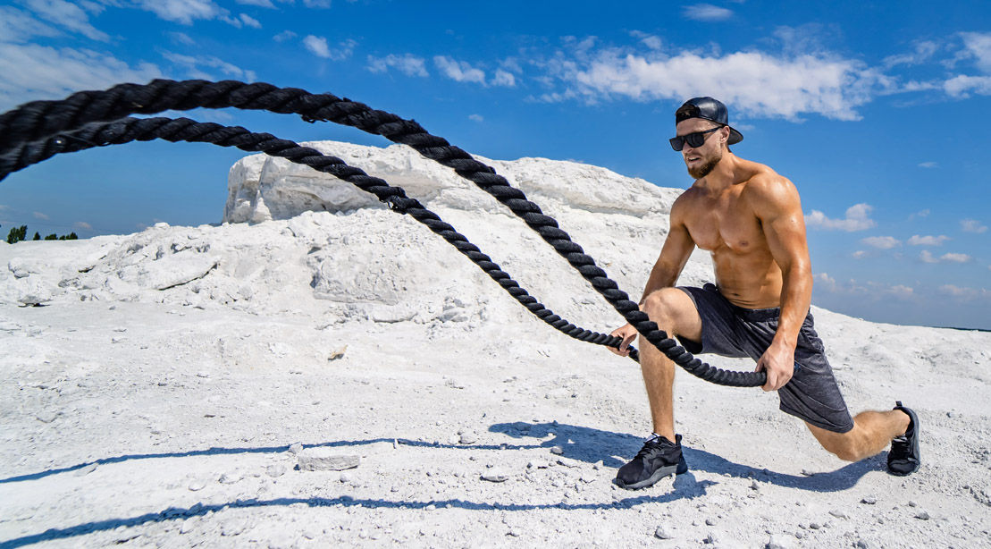 Physically-Fit-Man-Workingout-Outdoors-On-A-Mountain-Doing-Battle-Rope-Exercises