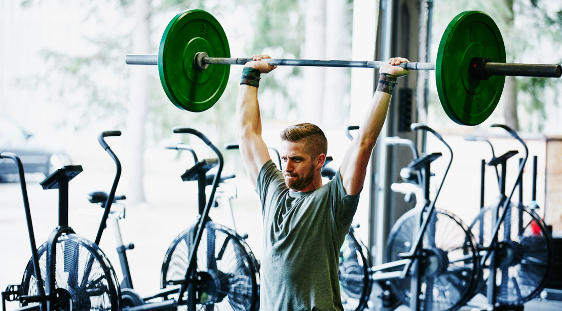 Man performing a barbell overhead press exercise