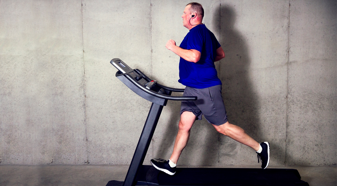 Overweight man running on a treadmill and losing fat