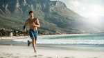 Man running on the beach for his vacation workout routine