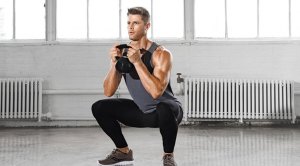 Fit man performing a Kettlebell Goblet squat exercise