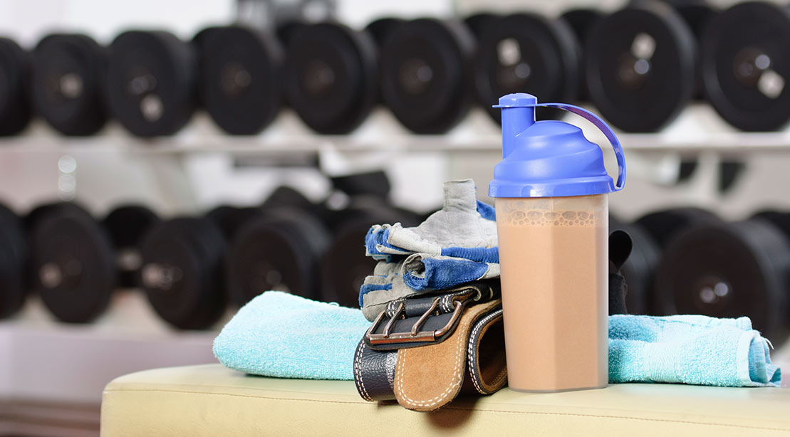 A protein shake on a gym bench. 