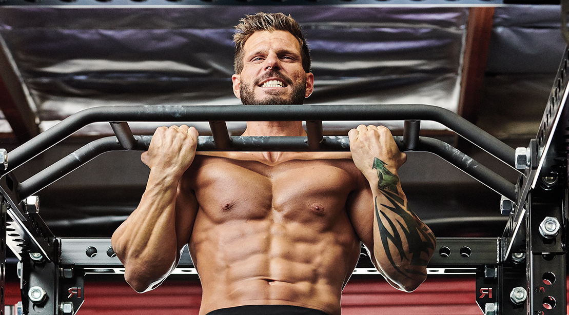 Fit muscular man working out his back and upper body doing a chin up