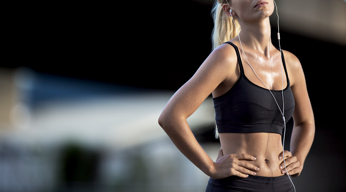 Fit sweaty female with her hands on her hips after a workout