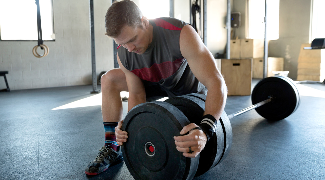 Man-Placing-Weights-Bar