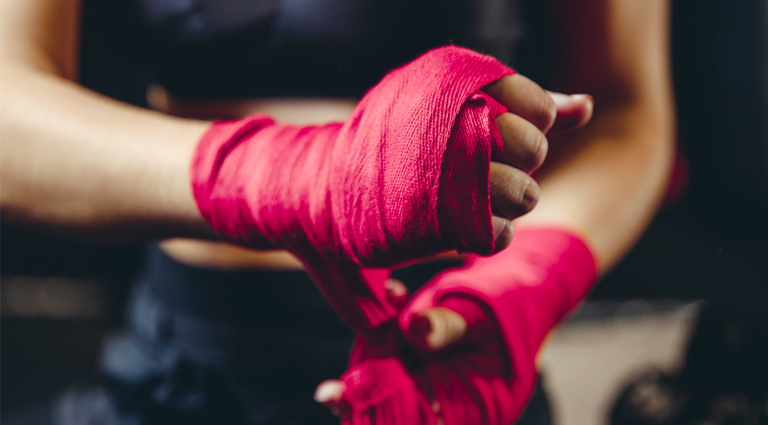 Female-Boxer-wrapping-her-hands-for-a-boxer