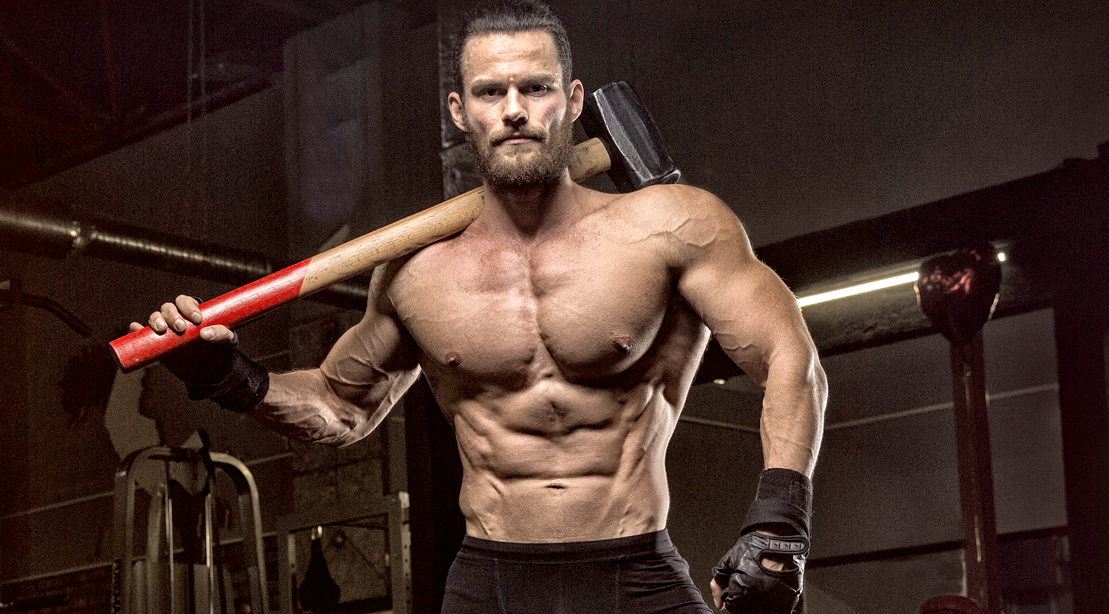 Muscular Man Holding a Sledge Hammer for Brute Strength training