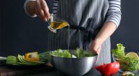 Cook Adding Oil to Salad