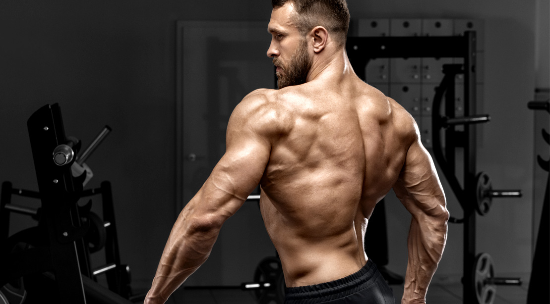 Fit male with a muscular upper back posing and showing his physique
