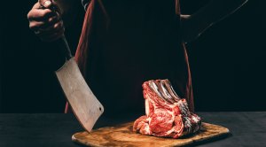 Butcher-Standing-Behind-Steak-Cuts-Cleaver.