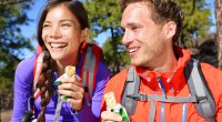 Couple-Wearing-Hiking-Gear-Eating-Protein-Bar