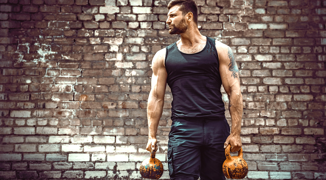 Man-In-Front-Of-Brick-Wall-Holding-Kettlebell