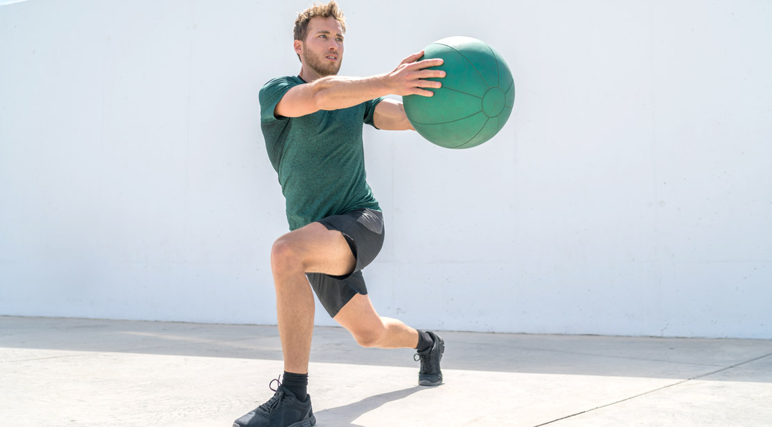 Man-Wearing-Green-Shirt-Doing-Rotational-Lunge-With-Medicine-Ball