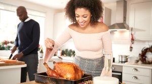 Couple-Preparing-Turkey-Dinner-Female-Basting-Turkey