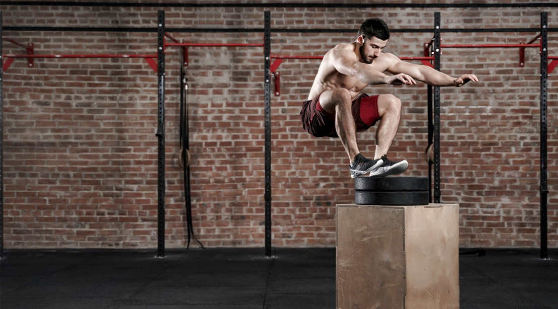 Fitness model working out his lower body and legs with a box jump exercise
