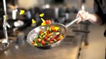 Chef-Tossing-Vegetables-In-Stainless-Steel-Pan