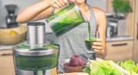 Woman-making-green-vegetable-juice-in-kitchen-sirtfood-diet