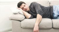 Man taking a nap on his couch during National Sleep Day