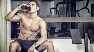 Topless-Male-Sitting-On-Bench-Post-Workout-Drinking-From-Shaker